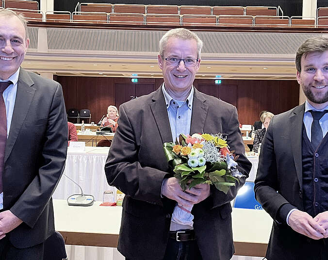 Erster Bürgermeister Fabian Müller und Bürgermeister Andreas Köster gratulieren Christof König zur Wahl als Leiter des Karl-Olga-Hauses.