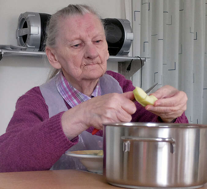 Seniorin schneidet Äpfel